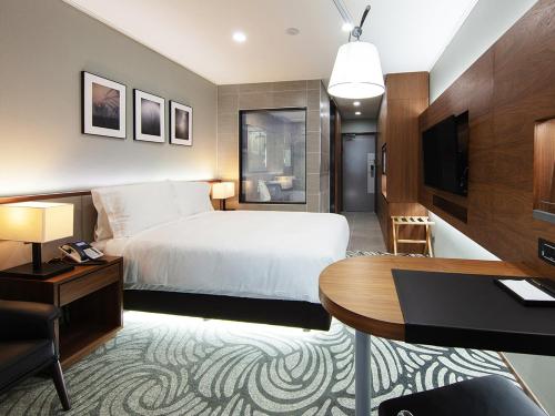 a hotel room with a bed and a desk at Best Western Plus GyeongJu in Gyeongju