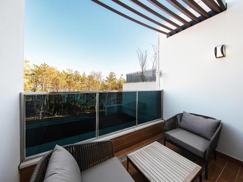 a balcony with a couch and a chair and a window at Best Western Plus GyeongJu in Gyeongju