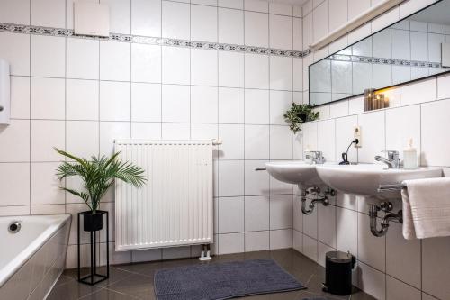 a white bathroom with a sink and a mirror at Klassen Apartments! Zentral und bequem, entdecken Sie Bad Schussenried in Bad Schussenried