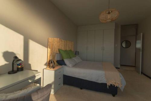 a bedroom with a bed with green pillows at Views from the Top in Edenvale