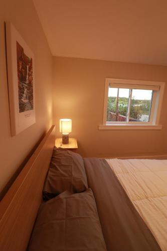 a bedroom with a bed and a lamp on a table at Waterfront House near Pomquet Beach- 2 bedrooms, Pet-Friendly in Antigonish