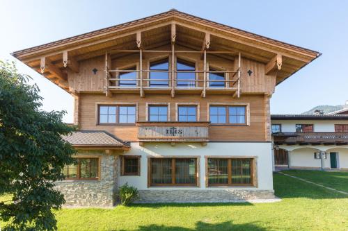 a large wooden house with a balcony on it at Hotel Garni Ransburgerhof in Flachau