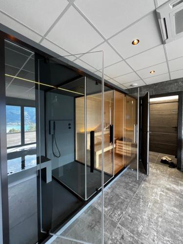 a glass wall in a room with a bed at Les Restanques du lac in La Chapelle