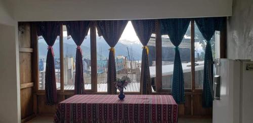 une table devant une fenêtre avec un chiffon de table violet dans l'établissement Casa Linda, à San Pedro de la Laguna