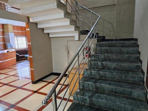 a staircase in a building with a metal railing at Deira City Residency in Kāsaragod
