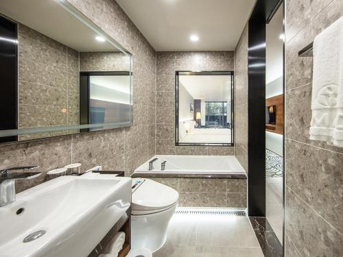 a bathroom with a tub and a toilet and a sink at Best Western Plus GyeongJu in Gyeongju