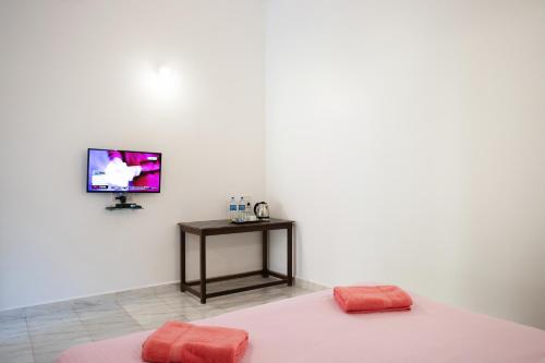 a bedroom with a bed and a tv on a wall at Hill Top Nest in Vagator