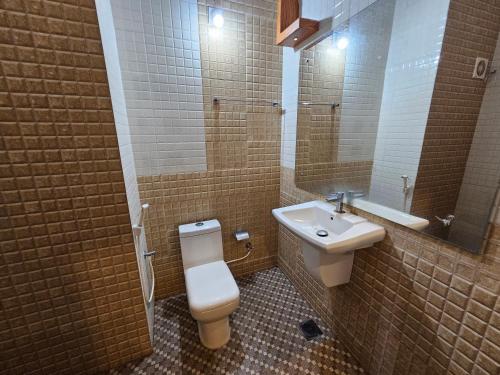 a bathroom with a toilet and a sink at Deira City Residency in Kāsaragod