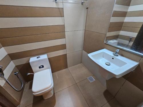 a bathroom with a toilet and a sink at Deira City Residency in Kāsaragod