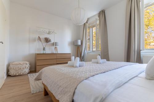 a white bedroom with a large bed and a window at Riverside Appartement - City Center in Krems an der Donau