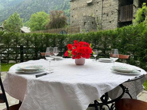 Una mesa blanca con un jarrón de flores rojas. en Full Apt x 6 to ski resort 4 km en Villaret