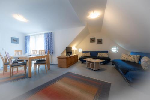Hotel Garni Hubertus-Nostalgie & Charme في فولبميس: غرفة معيشة مع أريكة زرقاء وطاولة
