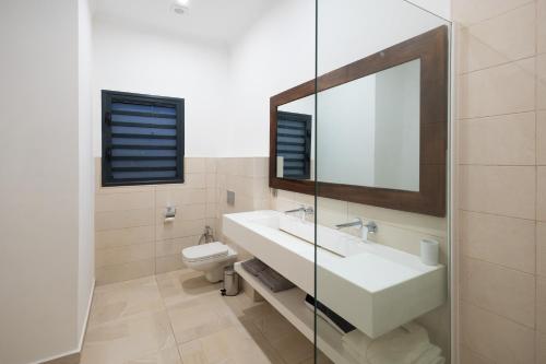 ヌシ・ベーにあるAlma Villasのバスルーム(洗面台、トイレ、鏡付)