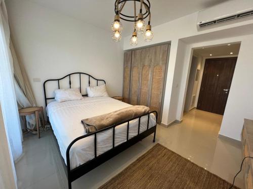 a bedroom with a bed and a chandelier at Studio EL Gouna G-Cribs in Hurghada