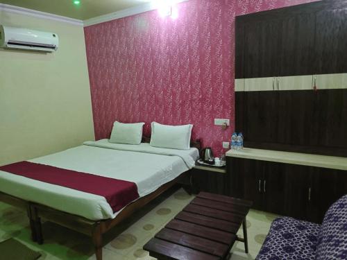a bedroom with a bed and a red wall at KINGS COCO RESORT in Konārka