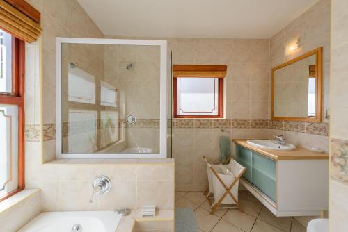 a bathroom with a tub and a sink and a mirror at San Lameer Villa 14117 - 3 Bedroom Superior - 6 pax - San Lameer Rental Agency in Southbroom