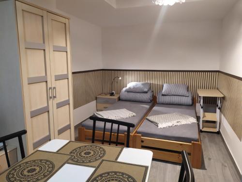 a room with two beds and a table and chairs at Apartamenty Barbara Ustroń Jaszowiec in Ustroń