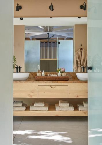 a bathroom with two sinks and a large mirror at Kwandwe Private Game Reserve - Ecca Lodge in Grahamstown
