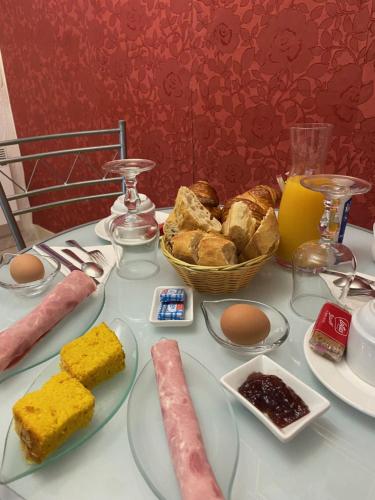 uma mesa coberta com pratos de comida e pão em Maison d'hôtes Le Beauséjour em Carcassonne