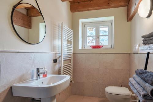 a bathroom with a sink and a mirror and a toilet at Residence V in Ponte di Legno