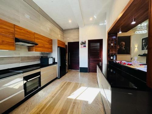 kuchnia z czarnymi urządzeniami i drewnianymi szafkami w obiekcie Pisano Luxury Apartments w mieście Lusaka