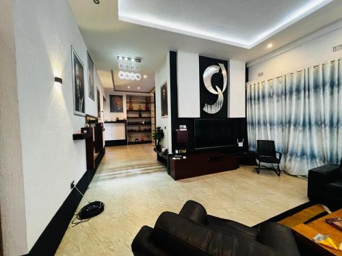 a living room with a couch and a television at Pisano Luxury Apartments in Lusaka