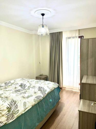 - une chambre avec un lit et un lustre dans l'établissement Comfortable apartment with a balcony 9, à Yalova
