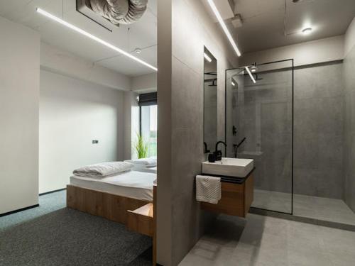 a bathroom with a bed and a sink and a shower at Hotel MiraMar smart room in Kovelʼ
