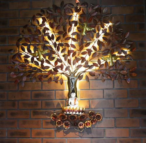 a chandelier with a tree on a brick wall at SScoconest Luxury Service Apartments in Chikmagalūr