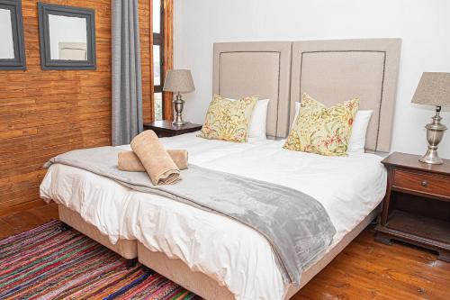 sypialnia z dużym białym łóżkiem z poduszkami w obiekcie Fireside Cabin w mieście Underberg