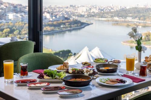 una mesa con comida y bebida y vistas al río en Clarion Hotel Golden Horn, en Estambul