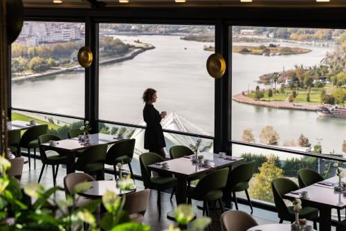 a woman standing in a restaurant with a view of a river at Clarion Hotel Golden Horn in Istanbul