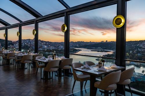 a restaurant with tables and chairs and a view of a city at Clarion Hotel Golden Horn in Istanbul