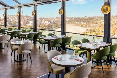 a restaurant with tables and chairs and a view of a river at Clarion Hotel Golden Horn in Istanbul