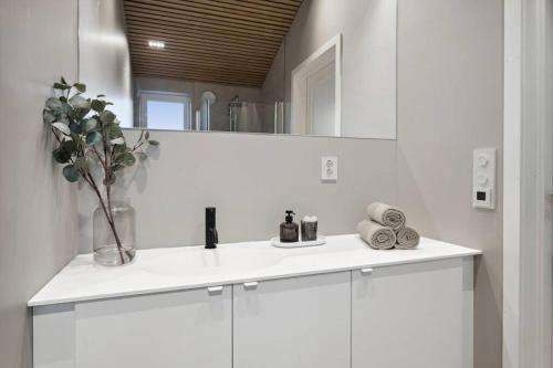 Baño blanco con lavabo y espejo en Cabin in Austevoll, en Austevoll