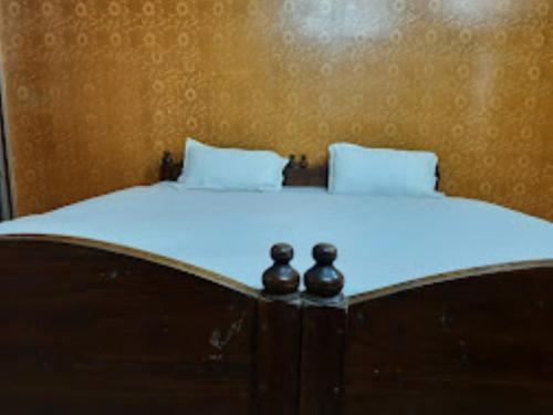 a bed with two pillows on top of it at Hotel santi vihar,Jehanabad in Jahānābād
