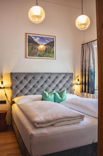 a bedroom with a large bed with two green pillows at Apart. Oberhof in Gerlos