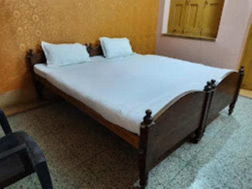 a bed with white sheets and pillows in a room at Hotel santi vihar,Jehanabad in Jahānābād