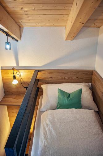 Una pequeña habitación con una cama y una almohada verde. en Apart. Oberhof, en Gerlos