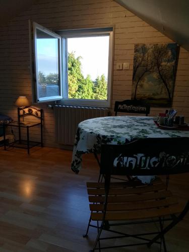 une chambre avec une table et deux fenêtres dans l'établissement La tourterelle, à La Rivière-Saint-Sauveur