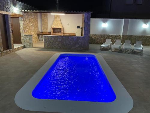 a large blue swimming pool in a room with chairs at Las Tres A in Segura de la Sierra