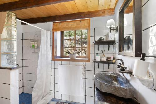 a bathroom with a stone sink and a window at Media Pipa in Puntagorda