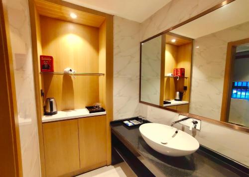 a bathroom with a sink and a mirror at Zhangjiajie ViVi Boutique Hotel in Zhangjiajie