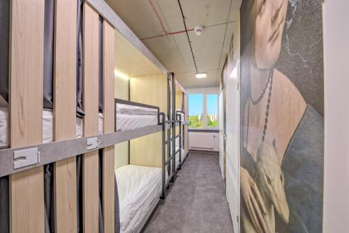 a corridor of a dorm room with bunk beds at Easy One Premium Art Hostel in Krakow