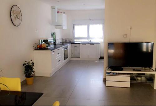 een keuken met een grote flatscreen-tv in een kamer bij Maison avec jacuzzi in Saintes