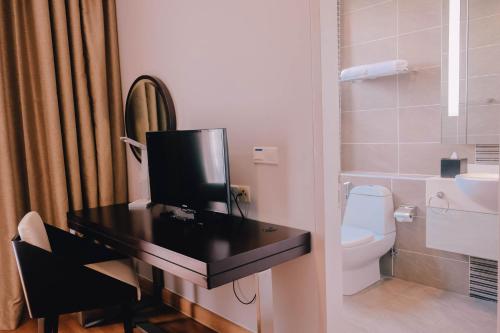 a bathroom with a black desk with a toilet at Trinidad Suites Johor, Trademark Collection by Wyndham in Nusajaya