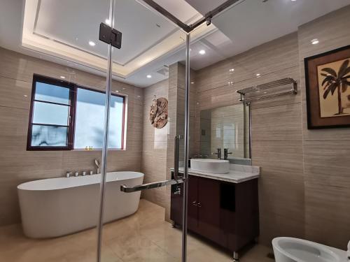 Thakho的住宿－MonMonBoutique Hotel，带浴缸、水槽和淋浴的浴室