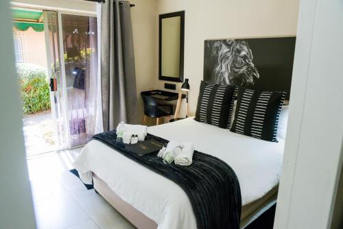 a bedroom with a bed with towels on it at Greenfields Guesthouse & Restaurant in Alberton