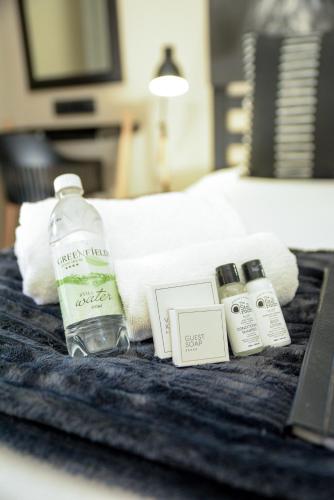 a bottle of water and other items on a bed at Greenfields Guesthouse & Restaurant in Alberton