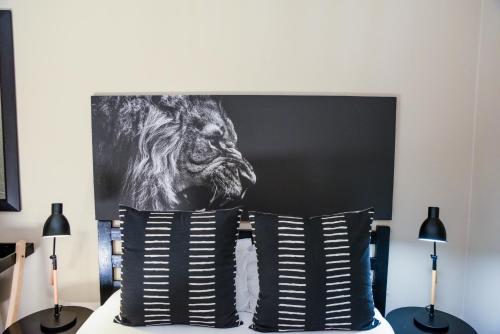 a painting of a lion on the head of a bed at Greenfields Guesthouse & Restaurant in Alberton